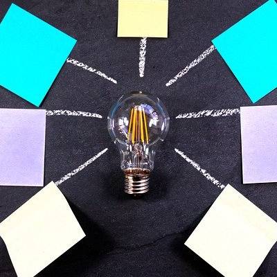 Idea concept with lightbulb and colorful sticky notes.