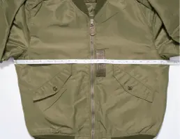 Green jacket measured with tape measure.