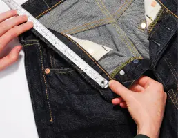 Measuring jeans waist with tape measure.